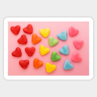 Heart-shaped colorful candy arranged in rainbow colors, on a pink background Sticker